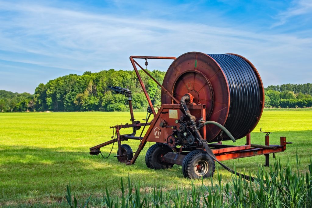 brown and black tractor on green grass field during daytime